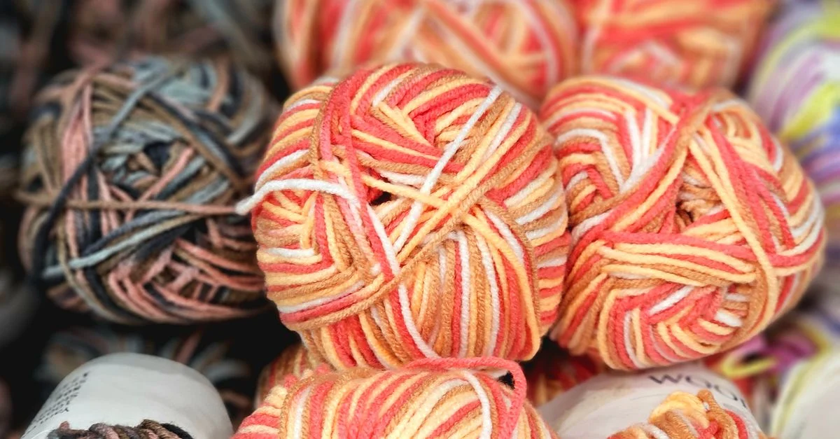 Pelotes de laine multicolores aux couleurs éclatantes, parfaites pour le tricot et les projets de loisirs créatifs.